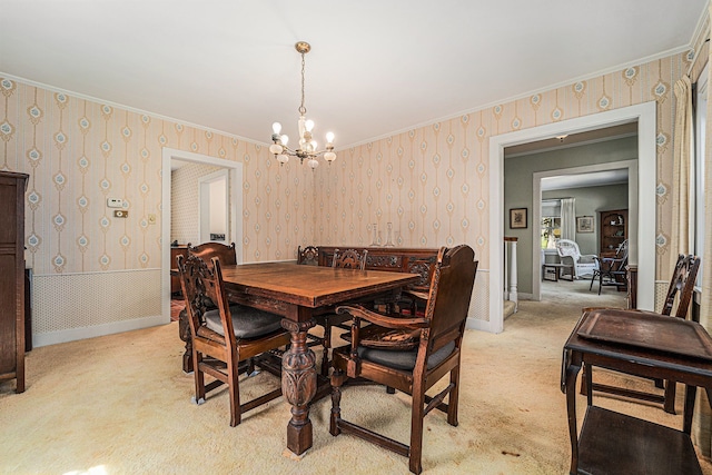 dining room with wallpapered walls, a chandelier, light colored carpet, and ornamental molding