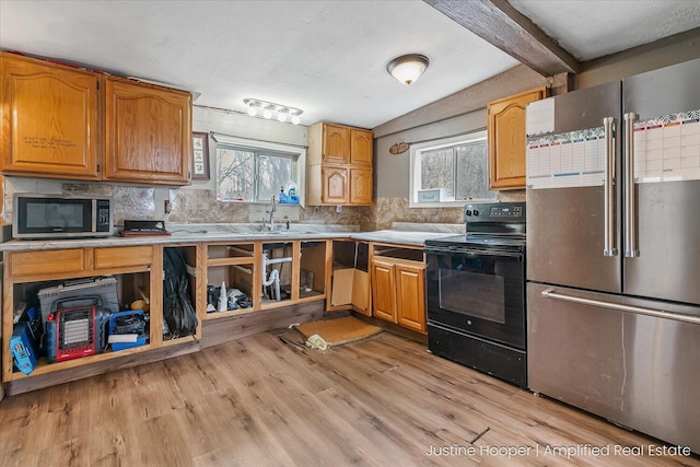 kitchen featuring backsplash, light countertops, light wood-type flooring, and stainless steel appliances