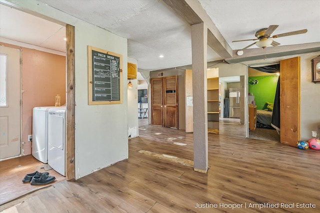 interior space with wood finished floors, visible vents, and washing machine and clothes dryer