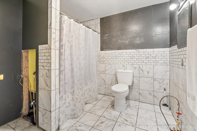 full bathroom featuring curtained shower, tile walls, marble finish floor, and toilet