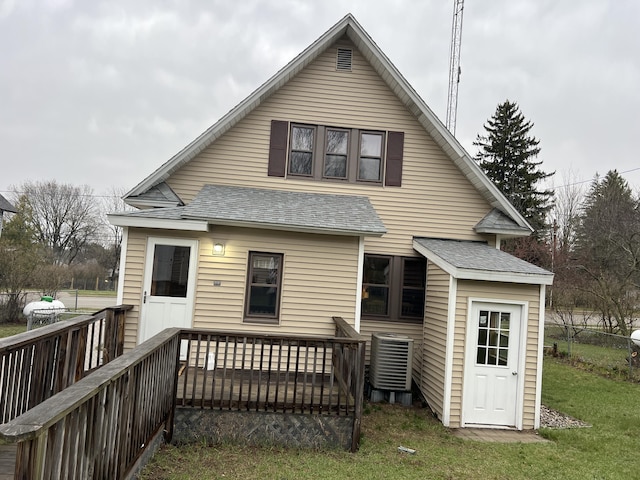 back of property featuring a shingled roof, a yard, central air condition unit, and a deck