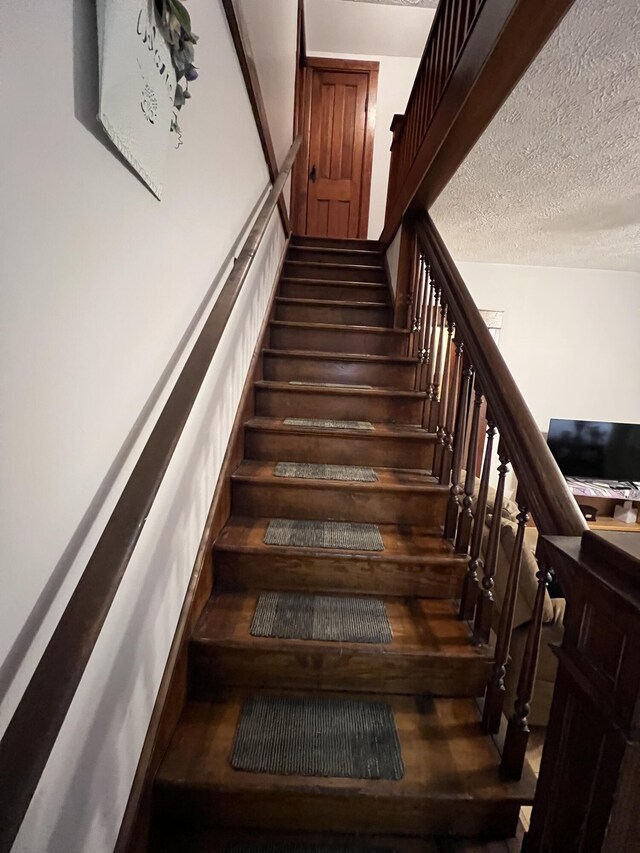 stairs with a textured ceiling