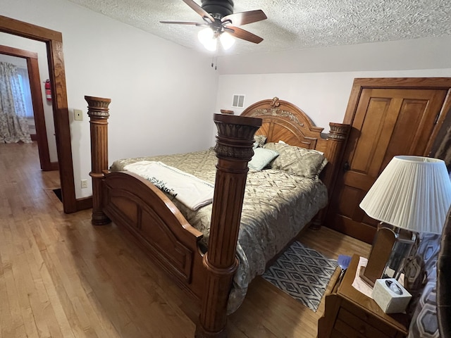 bedroom featuring visible vents, a textured ceiling, and light wood-style floors