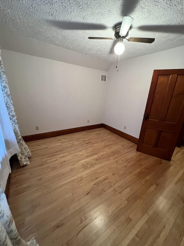 unfurnished bedroom with visible vents, light wood-style floors, baseboards, a textured ceiling, and ceiling fan