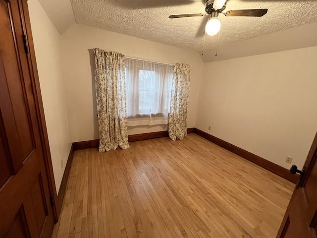 unfurnished room with light wood-style flooring, a textured ceiling, baseboards, and ceiling fan