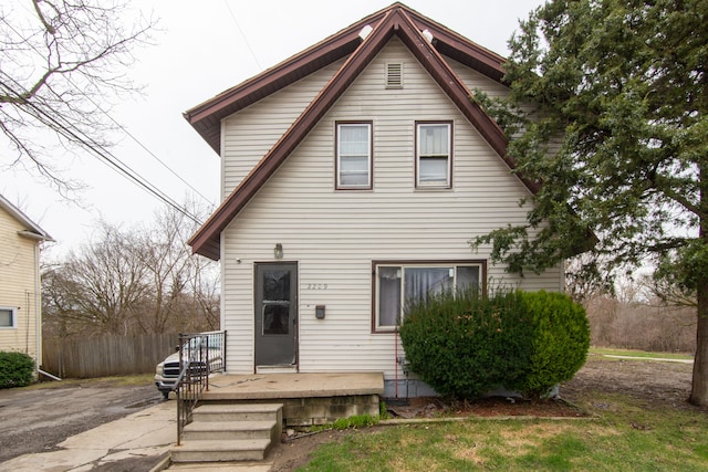 rear view of house featuring fence
