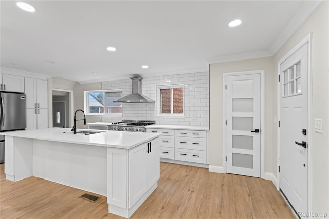 3761 Campbell St, Dearborn, MI 48124 - kitchen with wall chimney exhaust hood, freestanding refrigerator, tasteful backsplash, light countertops, and light wood finished floors