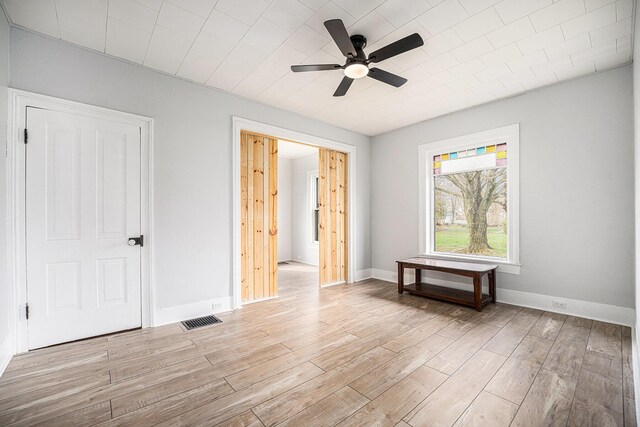 bedroom featuring baseboards, visible vents, light wood-style floors, and ceiling fan