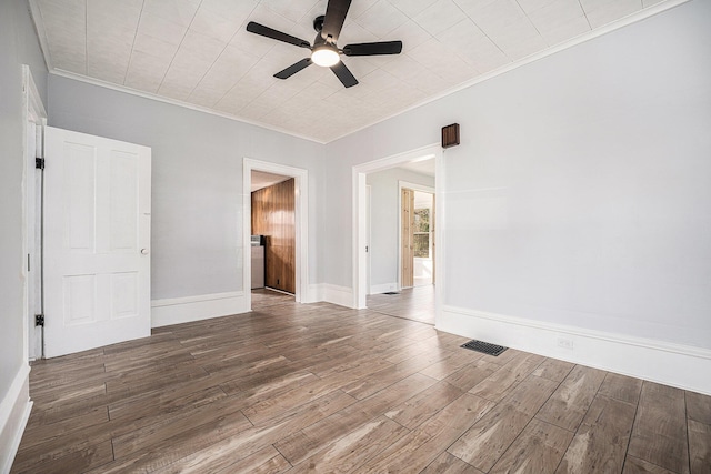 unfurnished room with wood finished floors, visible vents, ornamental molding, baseboards, and ceiling fan