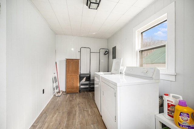 laundry room with wood finished floors, washer and dryer, and laundry area