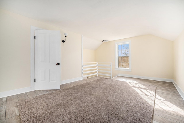 bonus room featuring lofted ceiling, wood finished floors, and baseboards