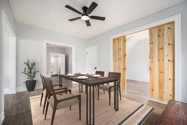 dining space with baseboards, a ceiling fan, and wood finished floors