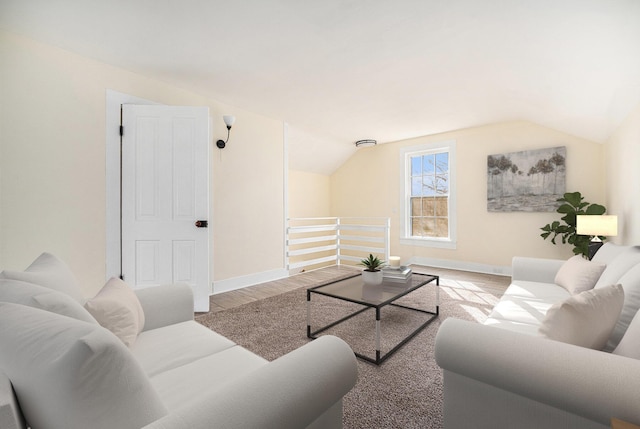 living area featuring lofted ceiling, wood finished floors, and baseboards