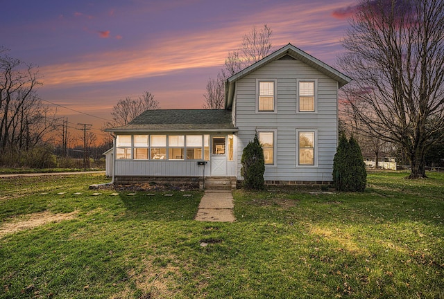 traditional home featuring a shingled roof and a front yard