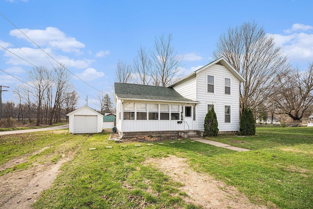 view of front of house with dirt driveway, a front lawn, an outbuilding, a detached garage, and roof with shingles