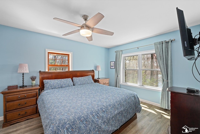 bedroom featuring baseboards, a ceiling fan, and wood finished floors