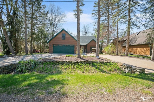 chalet / cabin featuring driveway and a garage