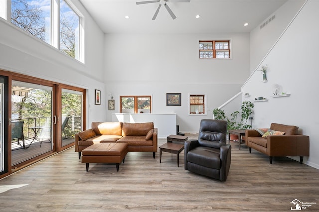 living room featuring visible vents, a high ceiling, and a wealth of natural light