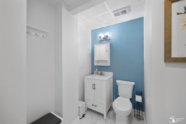 half bathroom featuring vanity, marble finish floor, baseboards, toilet, and visible vents