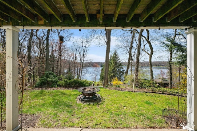 view of yard featuring a fire pit and a water view