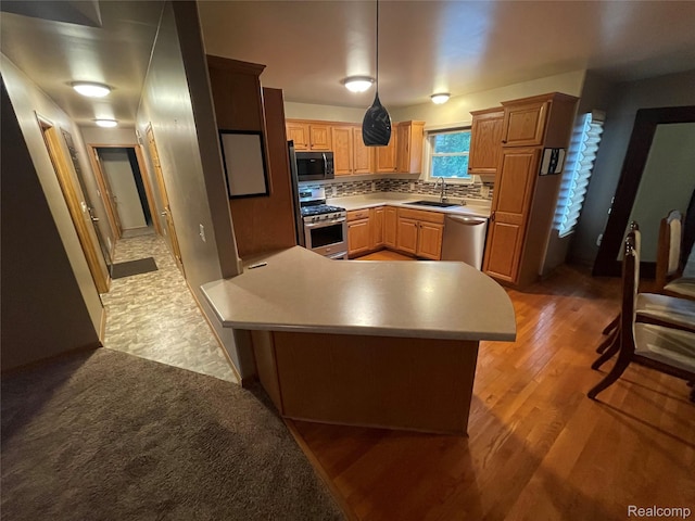 5652 N Lake Dr, Kimball, MI 48074 - kitchen featuring stainless steel appliances, light countertops, light wood-type flooring, tasteful backsplash, and a peninsula