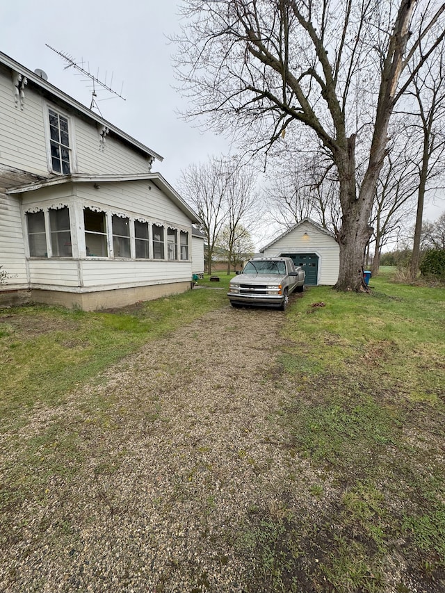 8083 S State Rd, Goodrich, MI 48438 - view of side of home with a garage, a yard, and an outbuilding