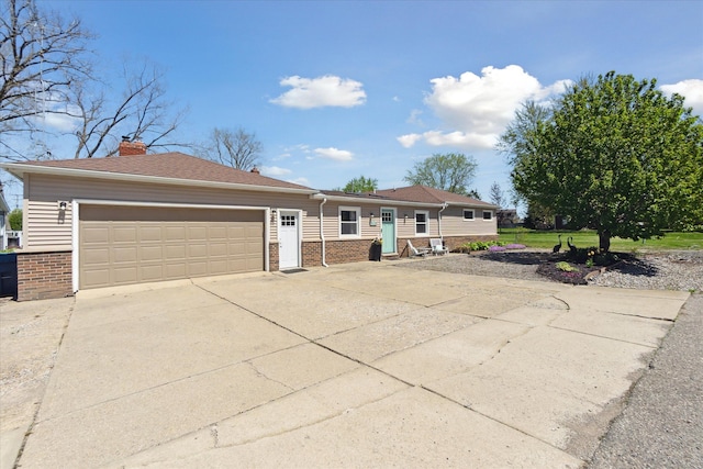 2510 Ruth Dr, Fenton, MI 48430 - view of front of house featuring brick siding, driveway, an attached garage, and a chimney