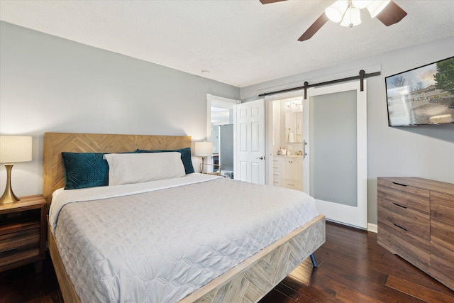 2510 Ruth Dr, Fenton, MI 48430 - bedroom with a barn door, dark wood-style flooring, baseboards, ensuite bathroom, and ceiling fan
