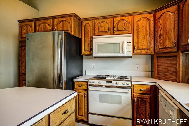 3076 Regency Pkwy, Zeeland, MI 49464 - kitchen with brown cabinetry, light countertops, and white appliances