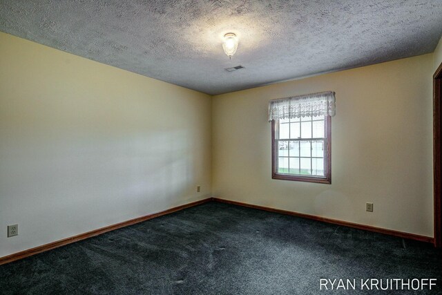 3076 Regency Pkwy, Zeeland, MI 49464 - spare room with a textured ceiling, dark carpet, visible vents, and baseboards
