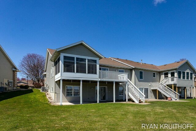 3076 Regency Pkwy, Zeeland, MI 49464 - rear view of house with a wooden deck, stairway, a yard, and a sunroom