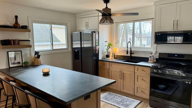 1006 Beach Dr, Lake Orion, MI 48360 - kitchen with appliances with stainless steel finishes, a sink, a ceiling fan, a kitchen bar, and a peninsula