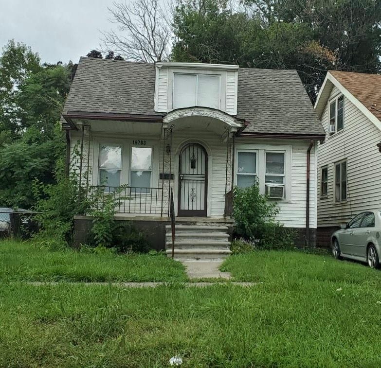 19703 Keating St, Highland Park, MI 48203 - bungalow-style house featuring a shingled roof, covered porch, a front yard, and cooling unit