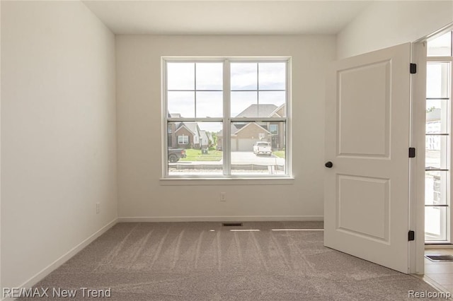 carpeted empty room with baseboards and visible vents