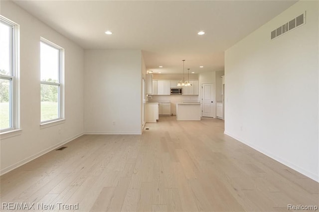 unfurnished living room with recessed lighting, visible vents, and light wood-type flooring