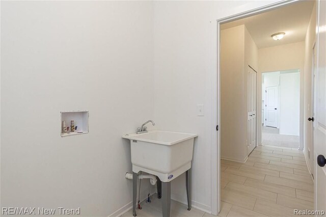 laundry room featuring baseboards, laundry area, and washer hookup