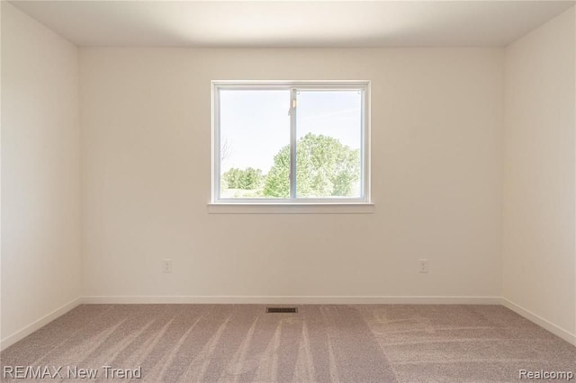 unfurnished room featuring light colored carpet, baseboards, and visible vents