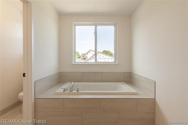 bathroom featuring a bath and toilet