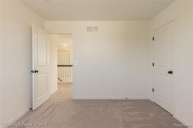 spare room with visible vents, carpet flooring, and baseboards