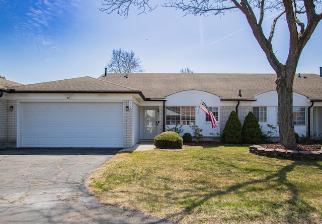 ranch-style house featuring an attached garage, driveway, brick siding, and a front yard