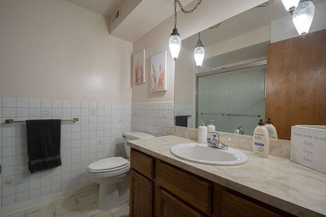 bathroom featuring a stall shower, tile walls, toilet, visible vents, and vanity