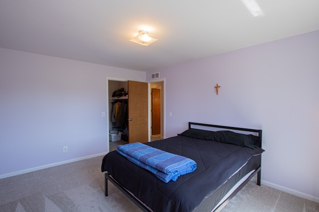 carpeted bedroom featuring baseboards, visible vents, and a closet