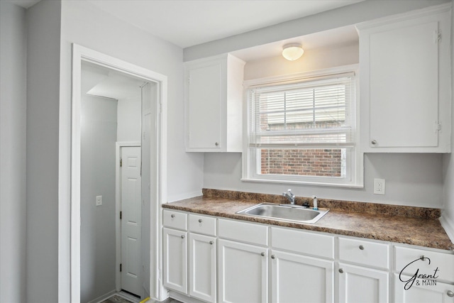 19931 Braile St, Detroit, MI 48219 - kitchen featuring white cabinets, dark countertops, and a sink