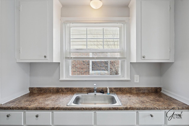 19931 Braile St, Detroit, MI 48219 - kitchen featuring white cabinets, dark countertops, and a sink