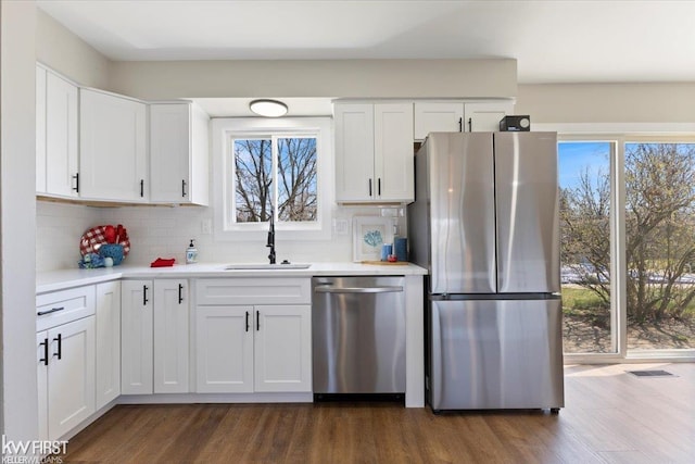 kitchen with stainless steel appliances, a sink, dark wood-type flooring, and a wealth of natural light