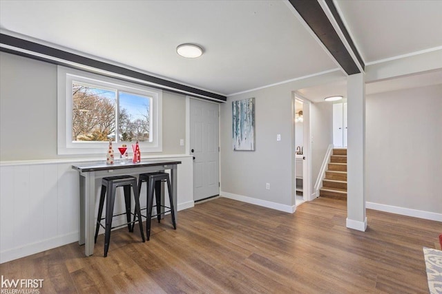 interior space featuring wood finished floors, baseboards, and stairway