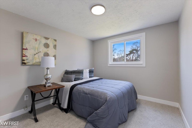 bedroom with a textured ceiling, baseboards, and light carpet