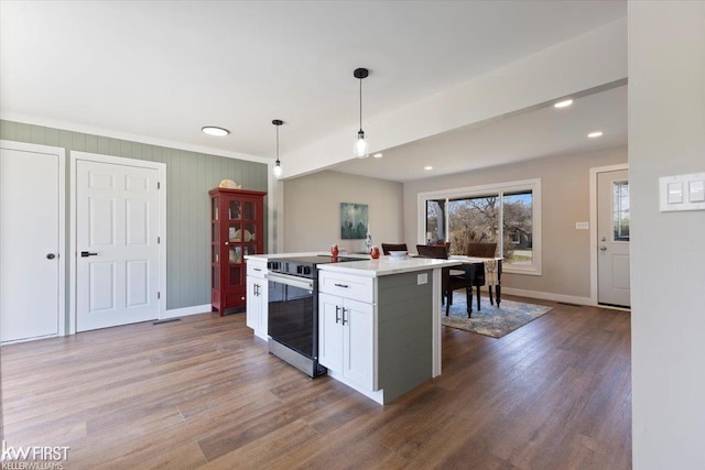 kitchen with range with electric stovetop, pendant lighting, light countertops, white cabinets, and baseboards