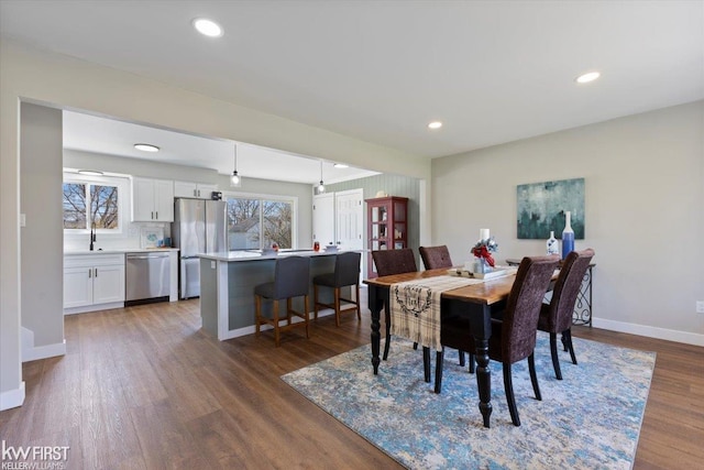 dining area with baseboards, wood finished floors, and recessed lighting
