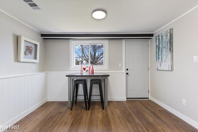 interior space featuring visible vents, baseboards, wood finished floors, and crown molding